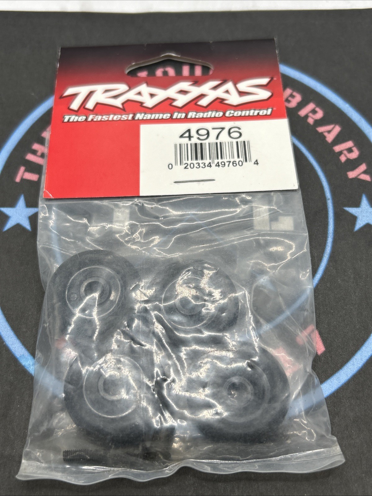 Traxxas. 4976 Wheelie Bar Wheels (4) Axles (2)